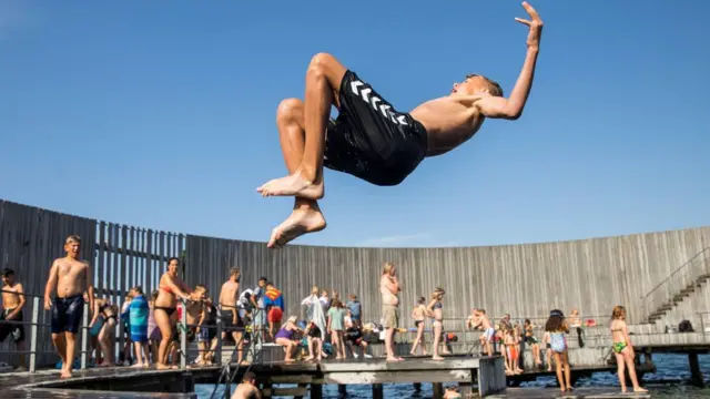 Boys jump in the water at the Snail on Amager in Copenhagen, Denmark June 25, 2019.