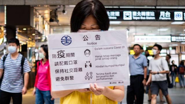 台湾铁路局职员在台北车站大厅展示防疫宣传标语（23/5/2020）