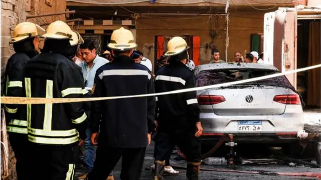رجال الأطفاء يقفون خارج مبنى الكنيسة بعد أن تمكنوا من إخماد النيران والسيطرة على الحريق.