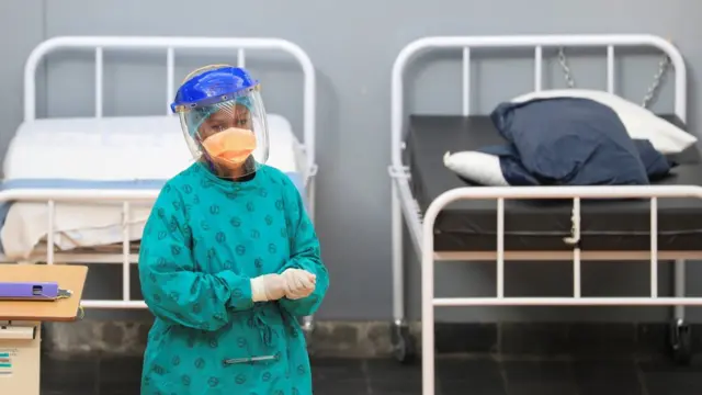 Un agent de santé passe d'un lit à l'autre dans un hôpital de campagne temporaire mis en place par Médecins Sans Frontières (MSF) lors de l'épidémie de coronavirus (COVID-19) dans le township de Khayelitsha, près du Cap