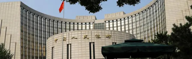 FILE PHOTO: Paramilitary police officers stand guard in front of the headquarters of the People"s Bank of China, the central bank (PBOC), in Beijing, China September 30, 2022