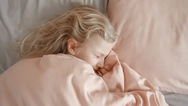Una niña durmiendo con cara de sufrimiento