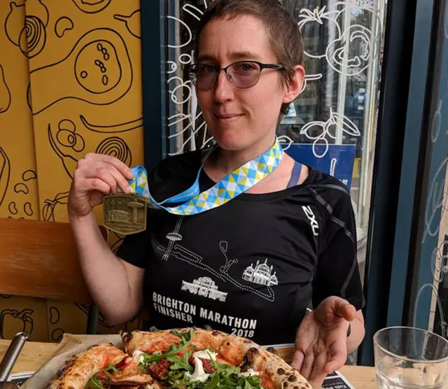 Amy Robson com medalha e pizza