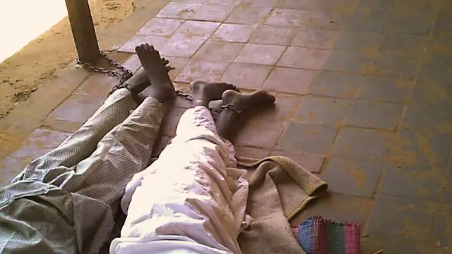 Garçons enchaînés à un poteau