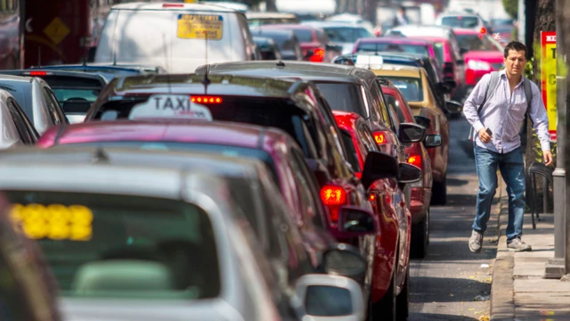 Hombre caminando junto al tráfico en México