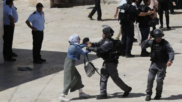 رجل شرطة إسرائيلي يدفع امرأة فلسطينية في المسجد الأقصى صبيحة عيد الفطر