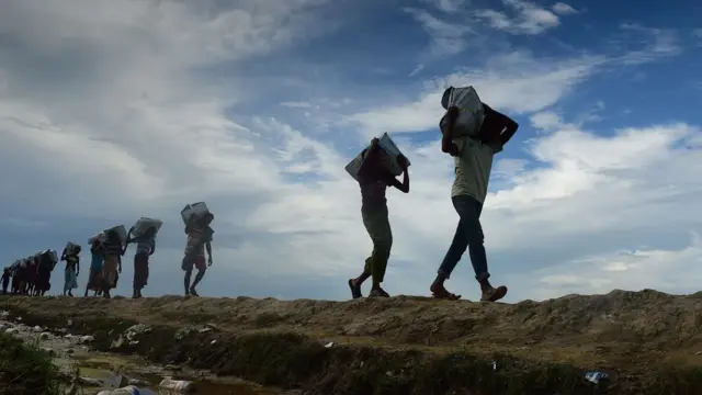 कंधों पर सामान ढोते रोहिंग्या
