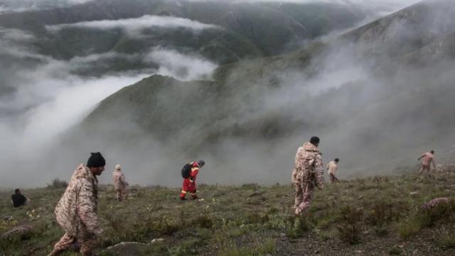 Photographs from the scene on Monday showed rescuers climbing a steep mountainside, shrouded in fog
