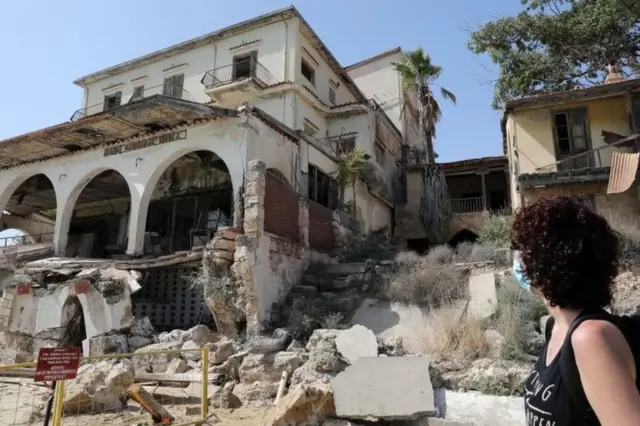 Maraş'ta harabe bir eve bakan kadın.