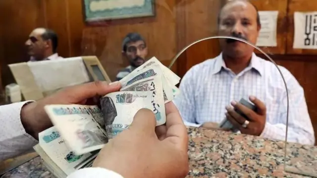 موظف يعد جنيهات مصرية