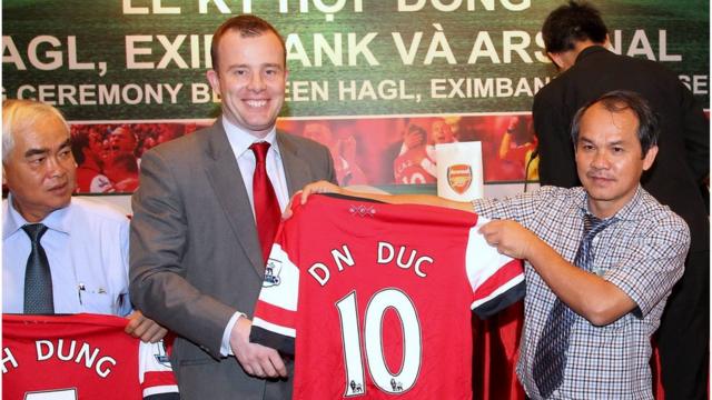 Ông Đoàn Nguyên Đức, hay Bầu Đức (phải) được Giám đốc Marketing Angus Kinnear của Arsenal trao tặng áo Arsenal. Ảnh chụp hồi tháng 5/2013.