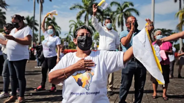 Una mujer canta canciones religiosas durante una procesión de la Virgen de Fátima dentro de los terrenos de la Catedral Metropolitana en Managua el 13 de agosto de 2022