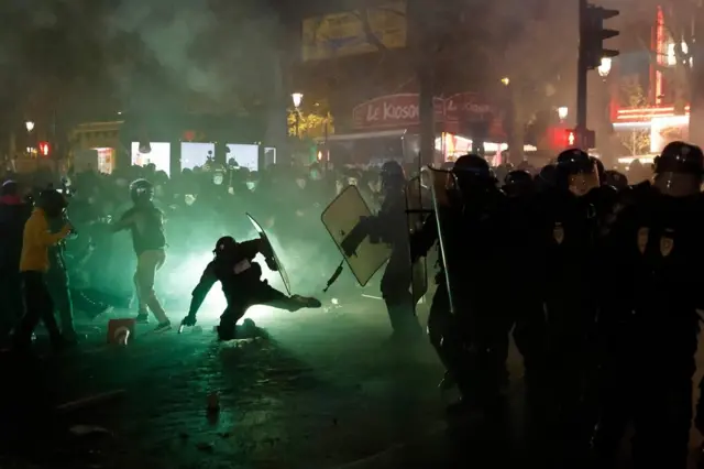 French riot police and protesters violently clash in a street