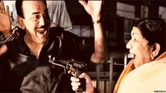 लता मंगेशकर सीआईडी नाटक में कलाकर शिवाजी साटम पर मज़ाक में पिस्तोल तानती हुईं.