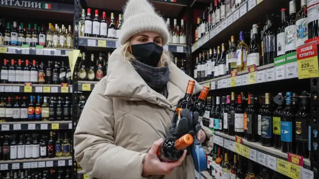 покупательница с бутылками вина в московском магазине