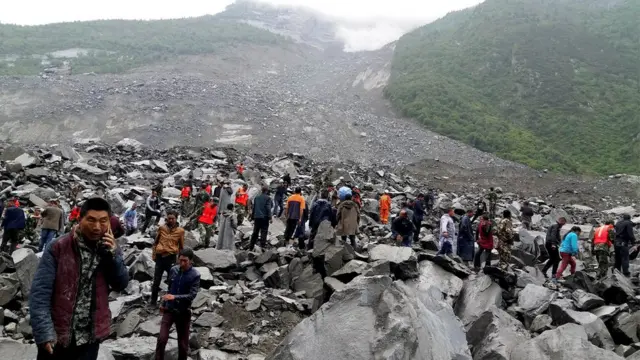 People search for survivors following a landslide in Xinmo Village in Maoxian county, 24 June 2017