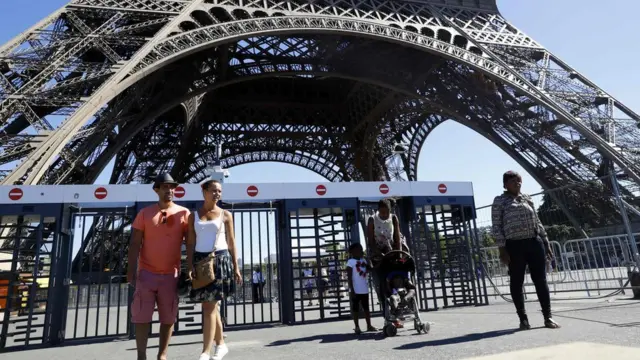 Turistas passeiam ao redor da Torre Eiffel