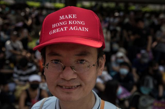 戴着类似特朗普标志性棒球帽的香港示威者，将帽子上的口号改为了“让香港再次伟大”