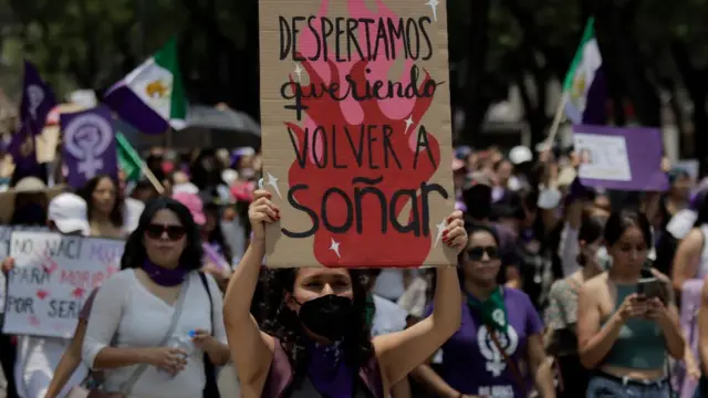 Una mujer se manifiesta con una pancarta durante una protesta.