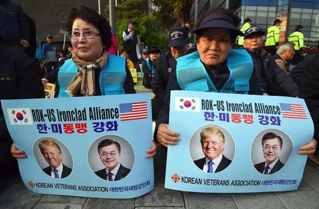 ผู้สนับสนุนทรัมป์ในเกาหลีใต้ถือป้ายแสดงการต้อนรับเขาใกล้ ๆ กับรัฐสภาสหรัฐ ฯ