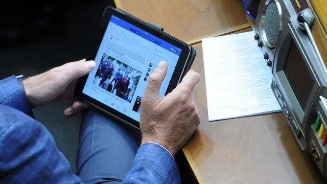 Депутат парламенту дивиться планшет