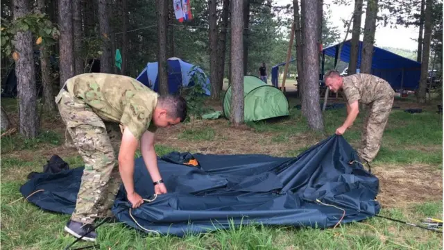 Ruski instruktori Evgenij i Alekej sklapaju šator nakon što je policija zatvorila kamp