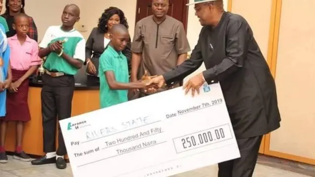 One of di children dey collect im price for di competition