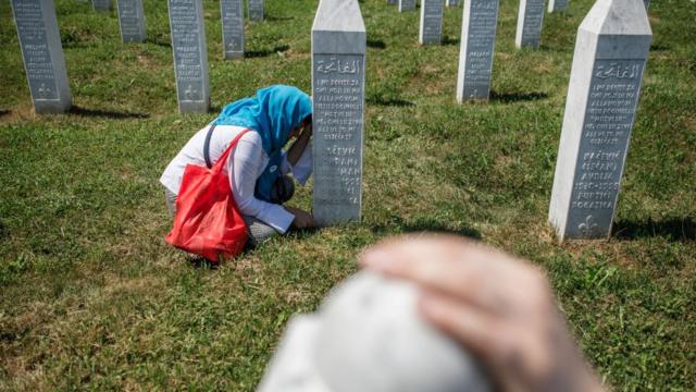 Una mujer bosnia junto a la tumba de un familiar en el cementerio donde reposan las víctimas de la masacre de Srebrenica.