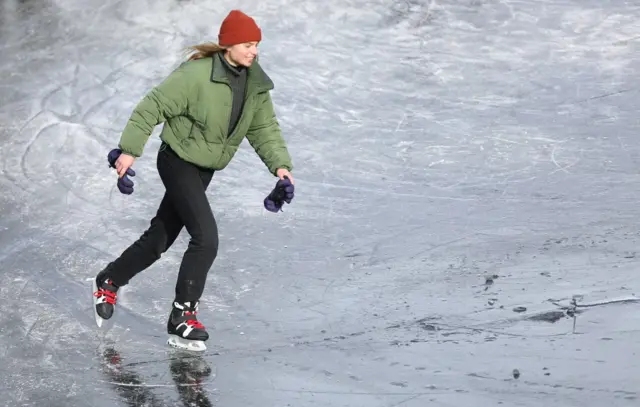 A woman ice skates during a cold snap across the country at the Prinsengracht in Amsterdam, Netherlands February 14, 2021.