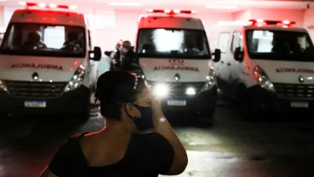 À noite epagbet site oficialfrente a três ambulâncias estacionadas, mulher a aparece com a mão no rosto, gesto que remete a preocupação