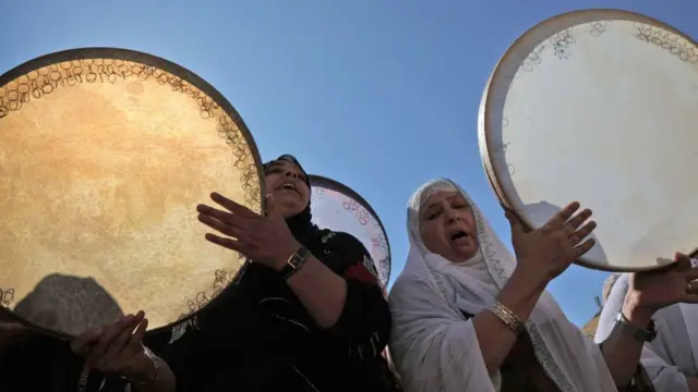 نساء يضربن على الدفوف احتفالا بذكرى المولد النبوي في عقرا في إقليم كردستان العراق