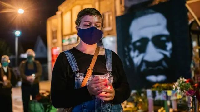 في الخلفية يظهر جورج فلويد