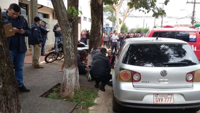 Personas atienden el cuerpo de Coronel yaciendo sobre la calle tras ser asesinado.