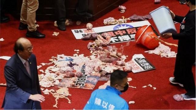 國民黨立委丟擲豬內臟抗議，民進黨批評浪費糧食（Credit: Reuters）
