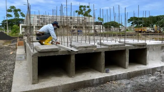 A construction worker, building extra niches in a cemetery