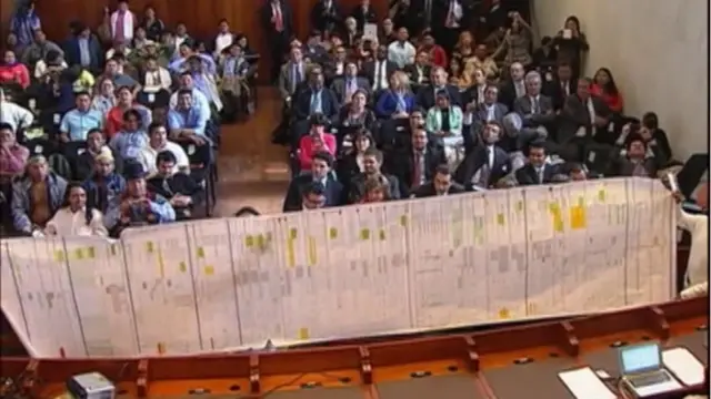 Presentan un documento ante una sala llena de personas