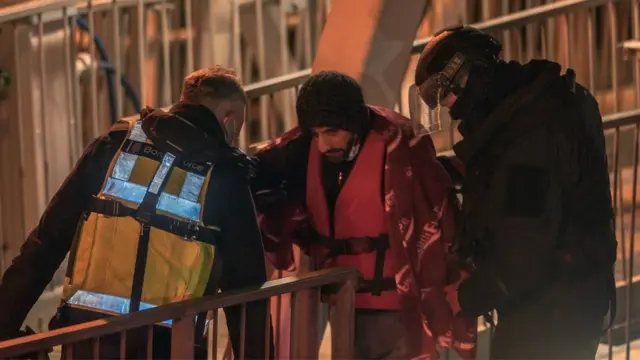 Un migrante baja del barco en el puerto de Dover, Reino Unido, tras ser rescatado del canal de la Mancha por la patrulla británica el 25 de noviembre de 2021.