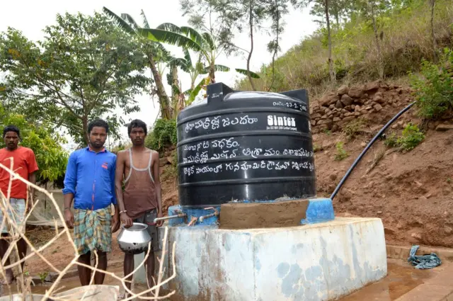 గ్రామంలో ఊటనీటి నిల్వ కోసం ఏర్పాటు చేసిన ట్యాంకు వద్ద నీరు పట్టుకుంటున్న గిరిజనులు