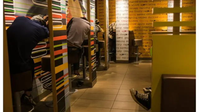 Sleeping people perched on stools