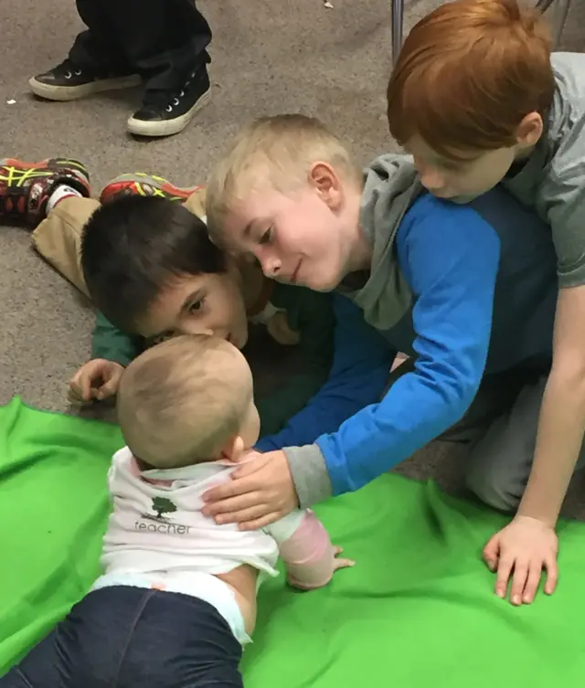 Un grupo de varones con un bebé durante un programa de Roots of Empathy.