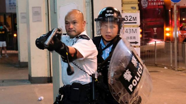 7月30日晚上的冲突期间，有警员擎枪指向示威者作出警告。