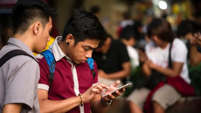 Dos jóvenes con el celular.