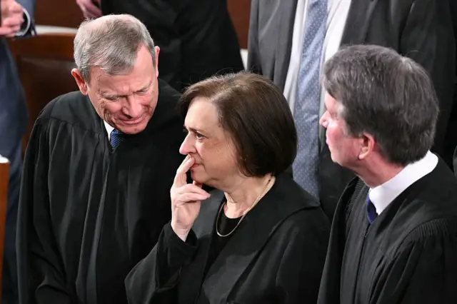 (L/R) Supreme Court Chief Justice John Roberts, Supreme Court Justice Elena Kagan, and Supreme Court Justice Brett Kavanaugh look on as US President Donald Trump arrives to deliver the State of the Union address in the House Chamber of the US Capitol in Washington, DC, on February 24, 2026.