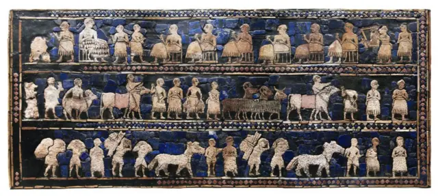 Panel de madera con incrustaciones de mosaico de concha, piedra caliza roja y lapislázuli mostrando gente y animales cargando bienes.