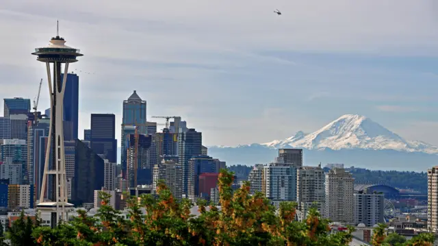 La silhouette de Seattle au premier plan, avec le mont Rainier enneigé en arrière-plan.