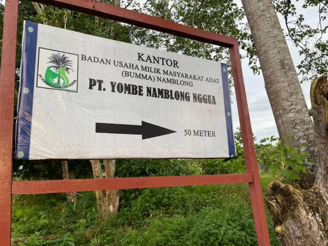 Plang kantor BUMMA Namblong, PT Yombe Namblong Nggua yang berada di pinggir jalan.