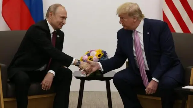 الرئيسان الأمريكي دونالد ترامب والروسي فلاديمير يتصافحان معاً 
