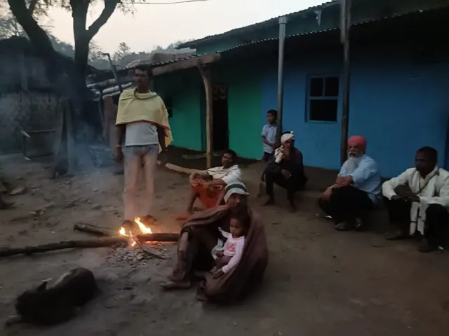 अंधार पडायला लागल्यावर गावकरी शेकोटी करून बसतात.