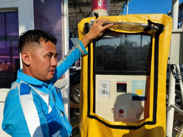 Para penumpang kapal feri di Pelabuhan Bakauheuni Lampung harus memindai tiket mereka di pintu masuk.