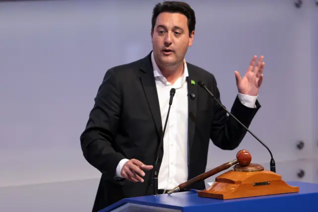 Ratinho Jr em pé, falando em um púlpito